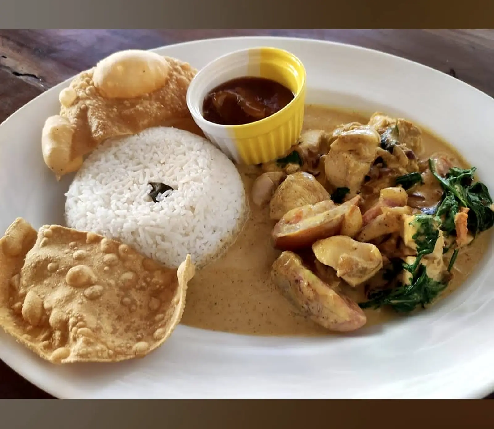 Creamy seafood curry with white rice, poppadoms and a small bowl of chutney