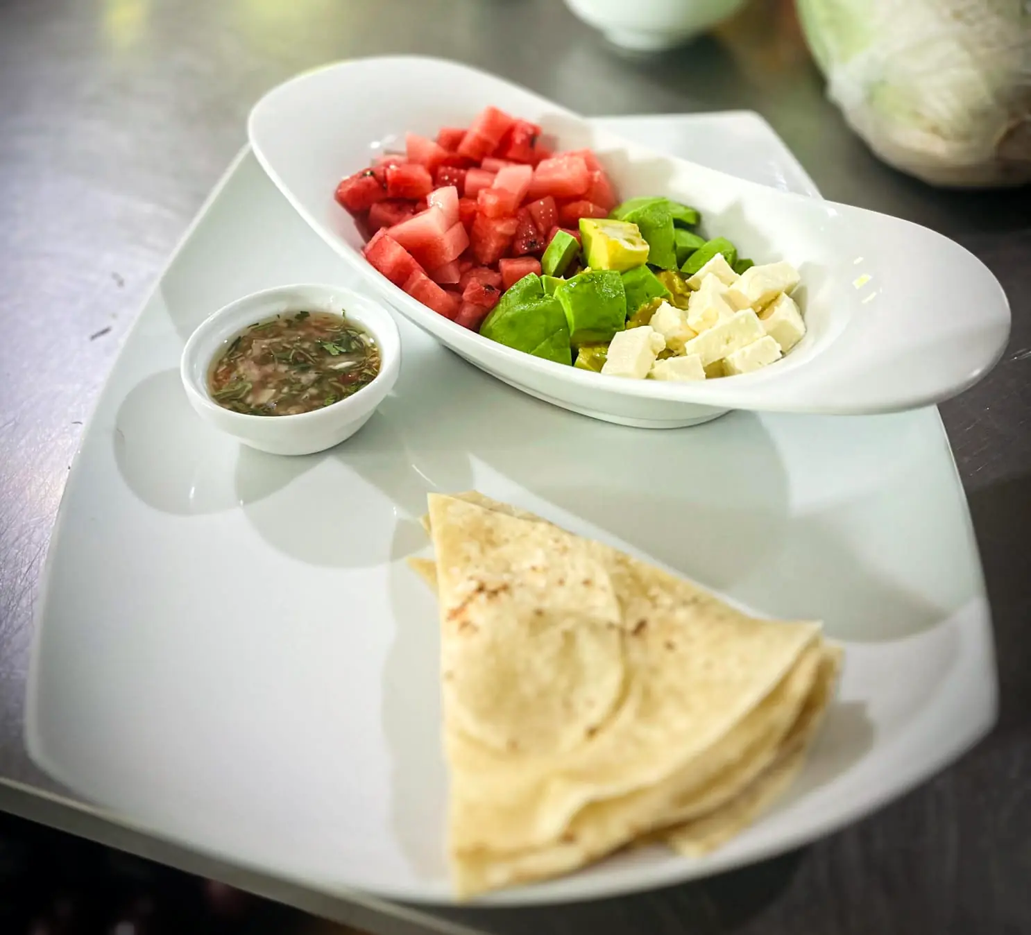 Watermelon, avocado and feta salad with a herb dressing and folded flatbreads